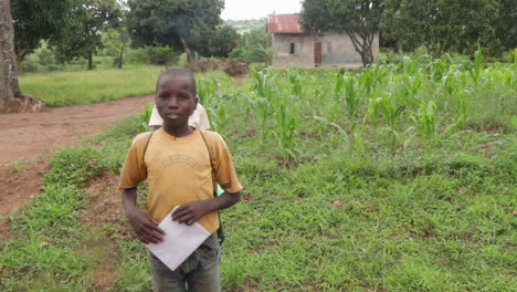 Kids-of-Ugandan-holding-papers-while-going-to-school-in-rural-area,-giving-directions-to-travelers