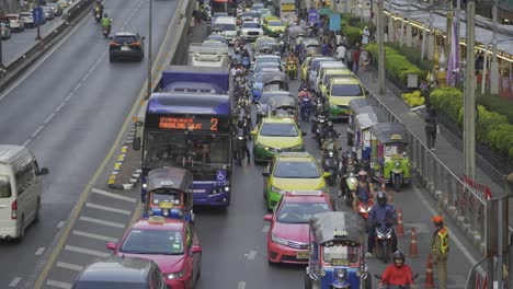 Bangkoks-Berüchtigter-Verkehr,-Verstopfte-Straßen,-Dichte-Autostaus,-Motorräder,-Die-Sich-Durch-Enge-Räume-Schlängeln,-Und-überfüllte-Kreuzungen,-Die-Das-Geschäftige-Und-Chaotische-Verkehrssystem-Der-Stadt-Unterstreichen