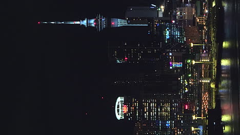 Auckland,-Nueva-Zelanda-Sky-Tower-Y-El-Horizonte-De-La-Ciudad-Por-La-Noche---Revelación-Aérea-De-Retroceso-Vertical