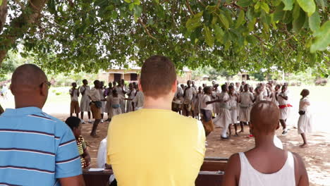 Un-Grupo-De-Personas-Observando-Un-Espectáculo-De-Danza-Cultural-Bajo-Un-Gran-árbol-En-Kampala,-Uganda.