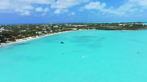 Toma-Circular-De-Un-Kitesurfista-Realizando-Trucos-En-Las-Brillantes-Aguas-Azules-De-Long-Bay-Beach