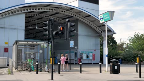 Exterior-De-Los-Jardines-De-La-Isla-De-La-Estación-DLR-Mientras-Los-Pasajeros-Entran-Y-Salen-De-La-Estación-En-Isle-Of-Dogs,-Londres,-Reino-Unido,-Julio-De-2023