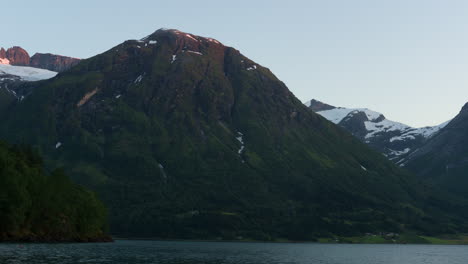 Timelapse-De-La-Luz-Del-Atardecer-Golpeando-Montañas-Redondas-Junto-A-Un-Fiordo-Noruego-En-El-Oeste-De-Noruega