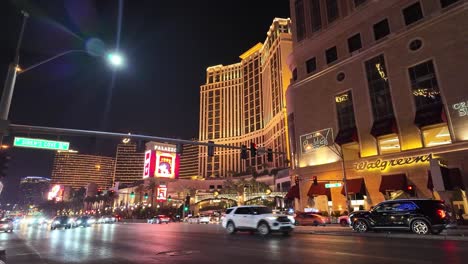 Coches-En-El-Strip-De-Las-Vegas-Por-La-Noche,-Iluminados-Por-Las-Luces-De-Empresas-Y-Hoteles.