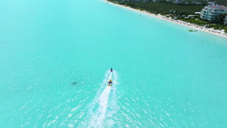 Forward-shot-of-water-tubing-in-Long-Bay-Beach,-making-splashes