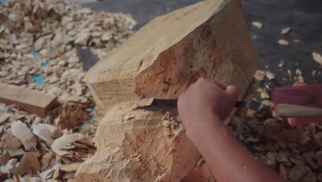 Handwerker-Modelliert-Ein-Stück-Holz-Mit-Meißel-Und-Hammer