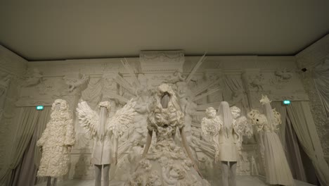 Intricate-white-fashion-designs-at-a-high-end-exhibition,-featuring-angelic-elements-and-luxurious-details