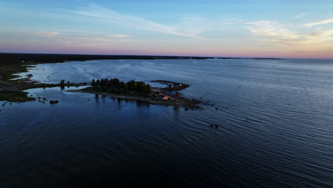 Aerial-view-approaching-the-Keskuskari-island,-summer-sunset-in-Kalajoki,-Finland