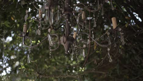 Elegant-outdoor-chandelier-adorned-with-crystals-in-a-lush-garden-setting