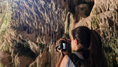 Mujer-Curiosa-Morena-Tomando-Fotografías-Con-Cámara-Dentro-De-Una-Cueva