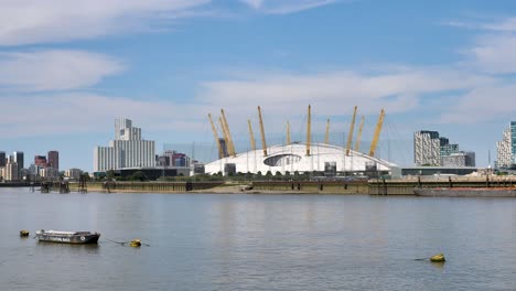 View-of-the-O2-Arena-along-the-Thames-set-against-the-London-cityscape,-United-Kingdom,-July-2023