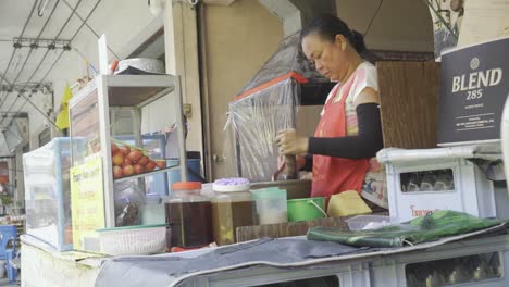 Eine-Frau-Bereitet-Auf-Einem-Geschäftigen-Straßenmarkt-In-Bangkok,-Thailand,-Gekonnt-Einen-Farbenfrohen-Papayasalat-Zu