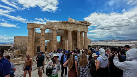 Crowd-visiting-the-Acropolis-in-Athens-under-a-bright-blue-sky-with-scattered-clouds