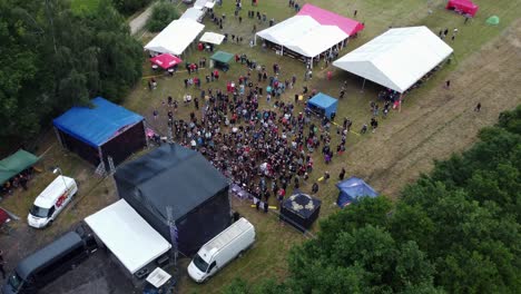 Drone-shot-of-a-small-music-festival,-cheering-fans