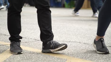 People's-Legs-Walking-Down-The-Street-With-Dog-At-50th-Dogwood-Festival-In-Siloam-Springs,-Arkansas