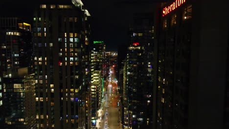 Vista-Aérea-Del-Tráfico-En-La-Concurrida-Calle-Drummond-Por-La-Noche-En-Montreal,-Quebec,-Canadá