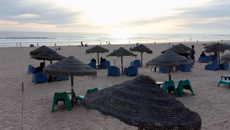 Paraguas-Descansando-En-La-Playa-De-Carcavelos,-Con-El-Mar-Al-Fondo