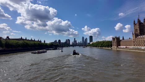 Scenic-view-of-the-River-Thames-in-London,-featuring-the-Houses-of-Parliament-and-Westminster-Bridge-with-boats-cruising-the-water-towards-Lambeth-Bridge