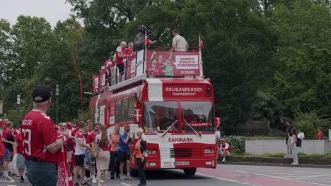 Vista-Frontal-Del-Autobús-Danés-Acercándose-Con-Aficionados-Animando-En-Frankfurt,-Alemania,-Durante-La-Eurocopa-2024.