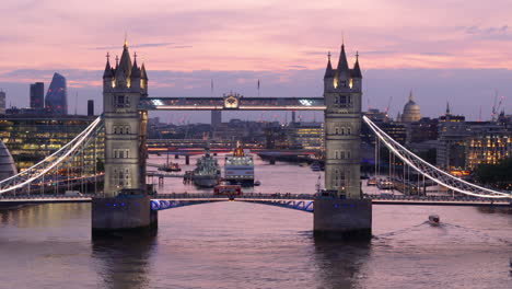 Twilight-aerial-toward-world-famous-Tower-Bridge-spanning-River-Thames-in-London