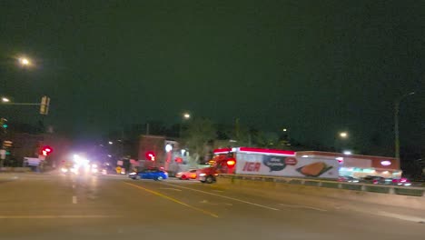 Camera-captures-cinematic-view-of-fire-truck-speeding-through-Montreal-streets-with-sirens-on-during-a-nighttime-emergency