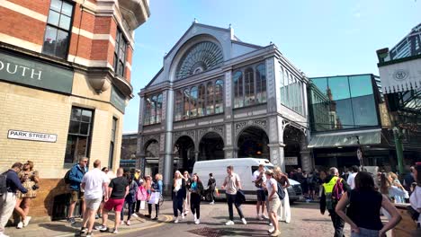 Geschäftiges-Straßenbild-Am-Borough-Market-Mit-Vielen-Menschen,-Die-Sich-An-Einem-Sonnigen-Tag-Vor-Einem-Historischen-Gebäude-Mit-Bogenfenstern-Versammelt-Haben-Und-Einem-In-Der-Nähe-Geparkten-Lieferwagen