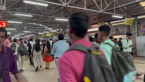 Commuters-walk-briskly-across-the-platform-bridge-at-railway-station