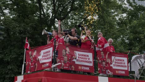 Patriotic-Danish-fans-on-top-of-bus-cheering-for-their-team-ahead-of-Denmark-match-in-Frankfurt,-Germany