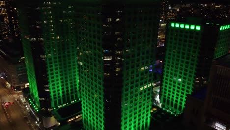 From-above,-building-in-Montreal,-Quebec,-Canada,-glowing-with-green-lights,-creating-a-vibrant-nighttime-scene