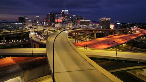 Aerial-nighttime-view-of-the-Orlando,-FL-interchange,-showcasing-illuminated-highways,-overpasses,-and-the-city’s-vibrant-skyline