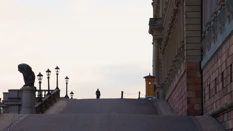 Royal-Guard-Marching-By-Royal-Palace-In-Stockholm,-Sweden,-View-From-Lejonbacken,-low-angle-static-shot