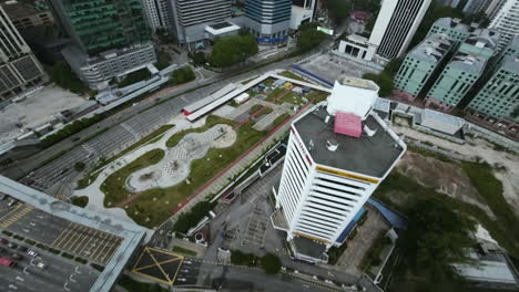 FPV-drone-shot-diving-down-the-Intermark-tower-in-cloudy-Kuala-Lumpur,-Malaysia
