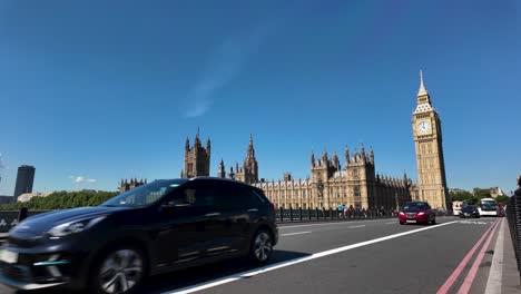 Vista-Del-Puente-De-Westminster-Con-Tráfico,-Con-Vistas-A-Las-Casas-Del-Parlamento-Y-Al-Big-Ben-Bajo-Un-Cielo-Azul-Claro-En-Londres