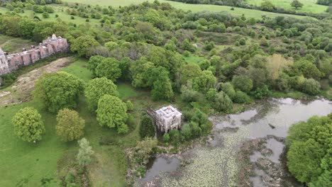 Shrine-by-lake-in-garden-at-abandoned-mansion-Hamilton-Palace,-Uckfield,-UK,-aerial-view
