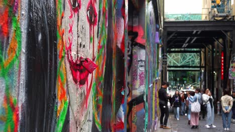 A-painted-lady-graffiti-with-lock-on-her-red-lip,-Hosier-Lane-a-cobblestone-laneway-with-a-vibrant-array-of-art-murals-on-the-walls-of-the-buildings,-a-creative-cultural-street-scene-in-Melbourne