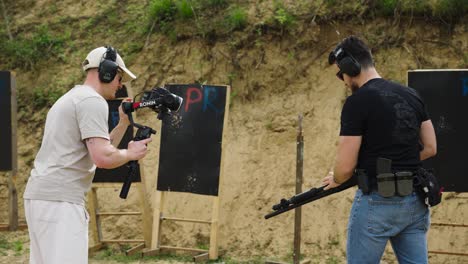 Camarógrafo-Con-Equipo-De-Cámara-Y-Persona-Cargando-Proyectiles-De-Escopeta-En-El-Arma