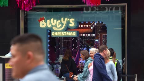 The-bustling-downtown-of-Melbourne's-Central-Business-District,-the-famous-Bluey's-Christmas-display-in-the-Myer's-windows-in-Bourke-Street-Mall-during-the-holiday-season,-slow-motion-shot