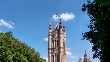 Victoria-Tower-in-Westminster,-London,-captured-on-a-clear-and-sunny-day-with-blue-skies-and-lush-greenery