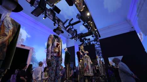 Exhibition-visitors-look-at-Dolce-and-Gabbana-outfits-displayed-on-mannequins-in-Milan,-Italy