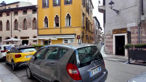 Typische-Veroneser-Architektur-Mit-Intensiv-Gelber-Fassade-Und-Auf-Der-Straße-Geparkten-Autos