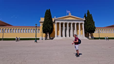 Hombre-Con-Mochila-Se-Encuentra-Frente-A-La-Sala-Zappeion,-Edificio-Neoclásico-En-Atenas,-Grecia