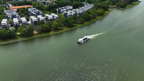 Vista-Aérea-Rodeando-Un-Ferry-Turístico-Que-Circula-Por-El-Lago-Putrajaya,-En-Malasia.