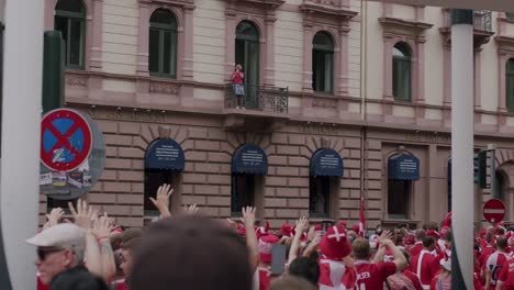 Shot-of-Danish-fans-walking-and-cheering-with-local-people-in-Frankfurt,-Germany