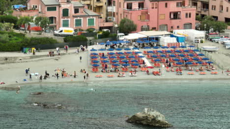 Monterosso-Al-Mare-En-Italia-Con-Turistas-En-La-Ciudad-Y-En-La-Playa-Con-Video-De-Drones-Moviéndose