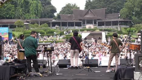 Blick-Hinter-Die-Kulissen-Einer-Band,-Die-Bei-Einem-Open-Air-Konzert-Vor-Großem-Publikum-Auf-Der-Bühne-Musik-Spielt