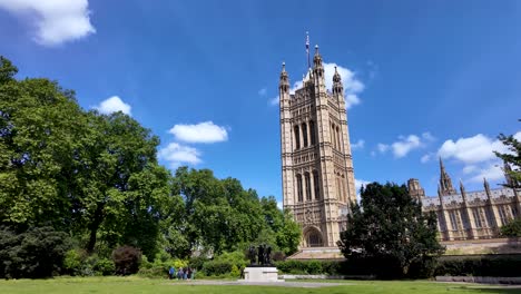 View-of-Victoria-Tower-and-the-Burghers-of-Calais-statue-in-the-serene-Victoria-Gardens,-Westminster,-under-a-clear-blue-sky