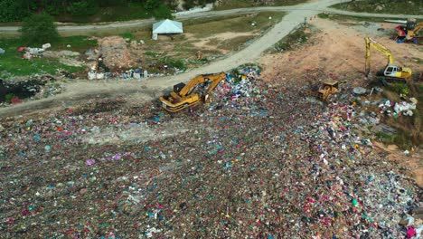 Aerial-birds-eye-view-drone-flyover-a-massive-abandoned-landfill-site-with-unsorted-wastes,-showcasing-environmental-sustainability,-microplastics-and-causes-of-global-warming-and-climate-change