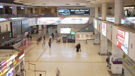 Vista-En-Timelapse-De-La-Espaciosa-Y-Moderna-Sala-De-Boletos-Del-Aeropuerto-Con-Varias-Pantallas-De-Información,-Tableros-Electrónicos-Y-Gente-Caminando