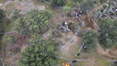 Flug-Mit-Einer-Drohne-Mit-Draufsicht-Auf-Einer-Motocross-Rennstrecke-Unter-Freiem-Himmel,-Auf-Der-Eine-Meisterschaft-Ausgetragen-Wird.-Wir-Sehen-Einen-Piloten,-Der-Mit-Seinem-Motorrad-Einen-Schritt-über-Einige-Steine-Macht