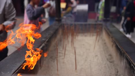 Burning-incense-sticks-in-large-temple-burner